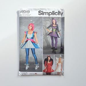 Könnte beinhalten: Ein Simplicity S9349 Schnittmusterumschlag mit Abbildungen von vier Kostümdesigns: ein metallisch blau-silbernes Weltraum-Outfit, ein lila-schwarzes Hexenkostüm, ein rotes Teufelskostüm mit Flügeln und ein weißes Engelkostüm mit Flügeln.
