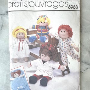 May include: Simplicity crafts/ouvrages 6968 pattern for soft sculptured dolls. The pattern includes instructions for making several dolls, each with different outfits. The dolls are approximately 40.5-45.5 cm tall.