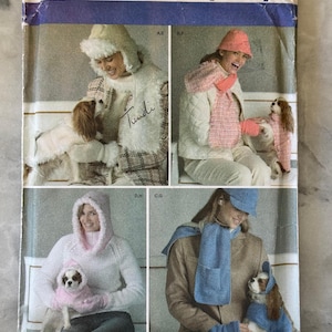 May include: Simplicity pattern 4316 for women's and dog's winter clothing. The pattern includes hats, scarves, jackets, and matching outfits for dogs. The image shows models wearing the finished garments in various colours and styles.