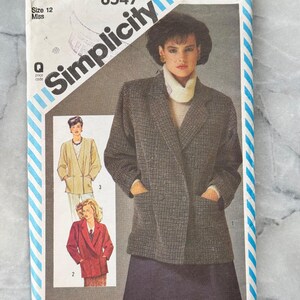 Könnte beinhalten: Ein Vintage-Schnittmuster von Simplicity, Größe 12 Miss, mit einer Frau in einem grau karierten Blazer. Die Schnittmusterhülle zeigt Illustrationen verschiedener Blazer-Stile und das Simplicity-Logo.