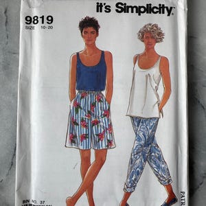 Puede incluir: Un patrón de costura Simplicity vintage titulado "It's So Easy". El patrón presenta ilustraciones de dos mujeres con una camiseta sin mangas azul y pantalones cortos florales, y una camiseta sin mangas blanca y pantalones estampados. La talla del patrón es 10-20.