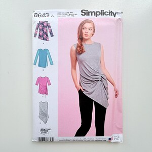 Könnte beinhalten: Simplicity Schnittmuster 8643 für ein ärmelloses Oberteil mit seitlicher Raffung. Die Verpackung zeigt ein Modell in einem grauen Oberteil und schwarzer Hose sowie Illustrationen von vier Varianten in floralen, blauen und rosa Stoffdesigns.
