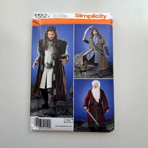 May include: Simplicity sewing pattern 1552A featuring costume designs. The pattern includes images of three different character costumes, each with long coats, fur accents, and swords. The Simplicity logo is visible in the upper right corner.