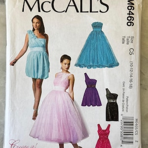 Puede incluir: Un sobre de patrón de costura McCall's con ilustraciones de vestidos de fiesta en varios colores, incluyendo azul, morado, rosa y negro. El sobre incluye el texto "McCall's" y el número de patrón M6466. La talla es C5 (10-12-14-16-18).
