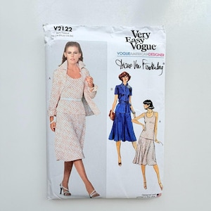 Op de afbeelding: Een Very Easy Vogue naaipatroon envelop V2122 van Diane Von Furstenberg. De witte papieren verpakking toont illustraties van twee kledingstijlen: een set met een jasje en rok met patroon, en een effen blauwe jurk met korte mouwen.