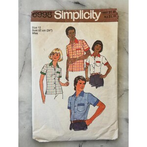 May include: A vintage Simplicity sewing pattern, number 6998, size 12, with shirt designs. The pattern includes bust measurements of 87 cm (34 inches). The cover displays the Simplicity logo and text.