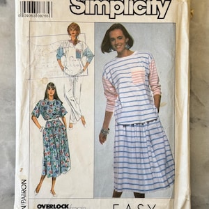 May include: A vintage Simplicity sewing pattern packet, size MD, with illustrations of women's clothing designs. The packet includes the text "Easy to Sew" and "Overlock/Serger". The designs include a striped top and skirt, and a floral dress.