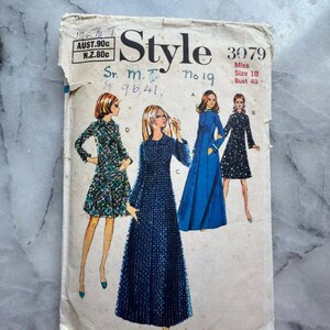 May include: Vintage sewing pattern titled "Style 3079" featuring illustrations of four different dress designs. The pattern cover is aged, with text including "Miss Size 18 Bust 40". The dresses are in various styles and colors.