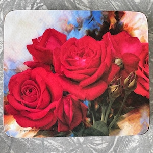 May include: A square coaster with a floral design. The image displays a bouquet of vivid red roses, some in full bloom, others as buds. The background has a watercolour effect with blue, white, and yellow tones. The text "Agency Art & Design Licensing" is visible.