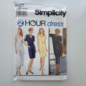 May include: Simplicity dressmaking pattern. The front cover shows illustrations of four dress designs, including a white lace dress, a navy blue dress with pockets, a yellow and white striped dress, and a black polka dot dress.