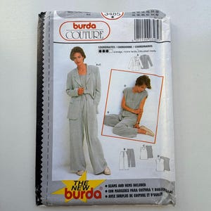 Op de afbeelding: Een vintage Burda Couture naaipatroonpakket met een vrouw in een lichtgrijs pak. Het pakket bevat afbeeldingen van het pak en andere bijpassende stukken. De tekst op het pakket bevat de merknaam, maatopties en instructies.