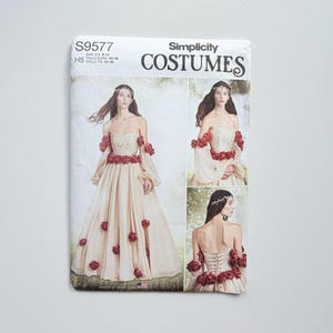 Könnte beinhalten: Eine Simplicity Costumes Schnittmusterhülle S9577 mit einem trägerlosen Kleid mit Korsett-Rücken, transparenten langen Ärmeln und roten Blumenverzierungen. Die Verpackung zeigt das Modell, das das Kleid in drei verschiedenen Ansichten trägt.