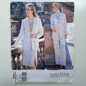 Puede incluir: Un patrón de costura vintage de Anne Klein con dos mujeres modelando trajes de color claro. Uno es un traje de falda con blazer, y el otro es un traje de pantalón con blazer. El número de patrón es 2681.