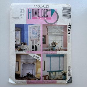 May include: A McCall's Home Decor sewing pattern featuring images of window treatments. The pattern includes instructions for roll-up and Roman shades. The front of the pattern is white with pink and teal accents. Pattern number 4724.