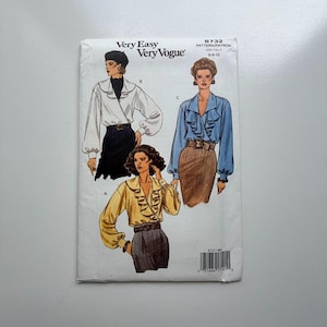 Puede incluir: Un patrón de costura vintage Very Easy Very Vogue. El patrón presenta ilustraciones de blusas con detalles de volantes y mangas abullonadas. La talla del patrón es 6-8-10.