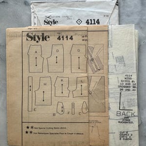 May include: A collection of vintage sewing patterns, featuring the "Style 4114" design. The patterns include diagrams and instructions for garment construction. The paper is aged with visible text and illustrations, offering a glimpse into classic sewing techniques.