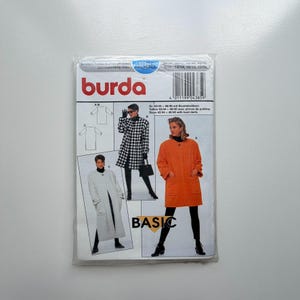 May include: A Burda sewing pattern packet featuring coat designs. The packet includes illustrations of coats in various styles, including a black and white houndstooth coat and an orange coat. The word "BASIC" is printed on the packet.