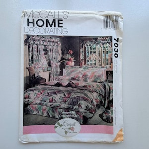 May include: A vintage McCall's Home Decorating pattern envelope. The front shows a bedroom scene with floral bedding, curtains, and a valance. The envelope includes the number 7030 and the text "Fabrics by Covington".
