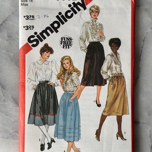 May include: A vintage Simplicity sewing pattern, size 14 Miss, with illustrations of blouses and skirts. The pattern packet has a red border and includes the text "Fuss Free Fit".
