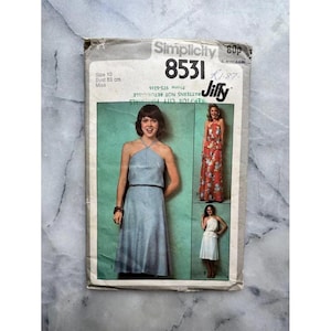 May include: Vintage Simplicity 8531 sewing pattern. The pattern features a halter dress design. The package includes a bust size of 83 cm. The pattern is labelled as "Jiffy".