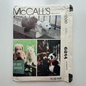 May include: Vintage McCall's pattern envelope featuring images of various stuffed animal designs. The envelope displays a polar bear, a black bear, a dog, a cat, a teddy bear, and a panda bear. The text "McCall's" is at the top.