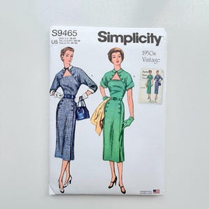 Può includere: Una busta per cartamodello Simplicity S9465 con illustrazioni di due abiti con scollo a goccia, dettagli a bottoni e cinture. Un abito è a quadri blu e bianchi, l'altro è verde tinta unita. Include il testo della taglia U.S. 16-24.