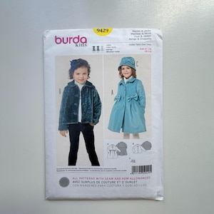 May include: A Burda Kids sewing pattern for children's coats and jackets. The pattern features illustrations of two different coat styles, one teal and one dark teal, with a bow detail. The pattern number is 9429.