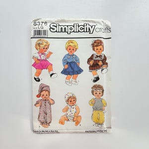 Könnte beinhalten: Eine Simplicity Crafts Schnittmusterhülle, Nummer 8376, Größe LG. Die Vorderseite zeigt Illustrationen von sechs Puppen in verschiedenen Outfits, darunter ein rosa Rock, ein blaues Kleid, ein braunes kariertes Kleid, ein gemusterter Strampler und ein gelbes Set.