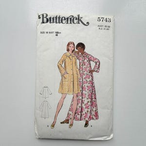 May include: Butterick 5743 sewing pattern envelope for size 18, 102cm bust. The front features illustrations of two coat styles: a solid yellow knee-length coat with a collar and pockets, and a long floral print coat with a collar and pockets.