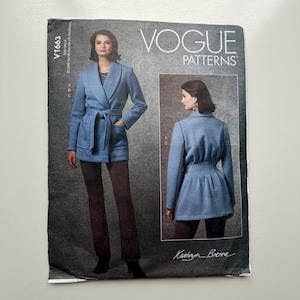 May include: Vogue Patterns sewing pattern V1663. The pattern features a blue wrap jacket with a tie belt and pockets, and a second view of a blue jacket with a cinched waist. The pattern includes the text "VOGUE PATTERNS" and "Kathryn Brenne".