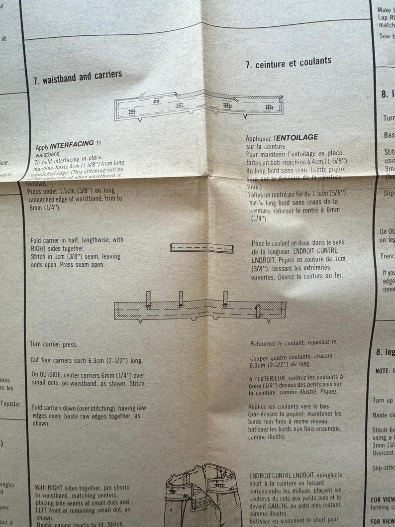May include: A folded paper sewing pattern with detailed instructions and diagrams for waistband and carrier construction. The text includes measurements in inches and fractions of an inch, along with sewing techniques.