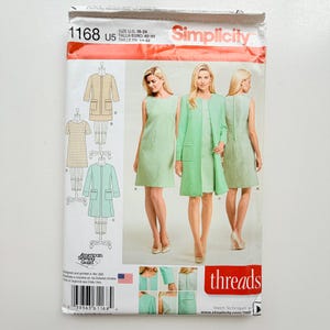 May include: A Simplicity sewing pattern envelope 1168 for sizes 16-24. The front displays illustrations and photographs of a sleeveless dress and a matching long-sleeved coat in light green. The text includes the brand name Simplicity and threads.