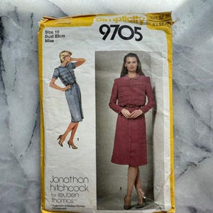May include: A vintage Simplicity sewing pattern, size 10, featuring a dress design. The pattern envelope is yellowed with age and includes illustrations of the dress styles. The bust size is 83cm. The pattern is by Jonathan Hitchcock for Reuben Thomas.