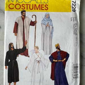 May include: A McCall's Costumes sewing pattern, M7229, with illustrations of religious costumes. The pattern includes sizes Ex-Small (77.5-80 cm). The cover is yellow with the brand name and costume illustrations.