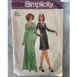 Könnte beinhalten: Vintage Simplicity Schnittmuster 6024 mit Illustrationen von zwei Kleidern. Das Muster enthält Größenangaben für Damen, Größe 10, mit einem Brustumfang von 82 cm. Das Cover ist lila und weiß.