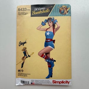 May include: A Simplicity sewing pattern envelope for a DC Comics Bombshells Stargirl costume, model 8433 H5. The cover features a blue and white star-patterned romper, matching gloves, goggles, and boots, with a character illustration and text.