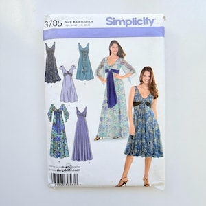 Può includere: Cartamodello Simplicity 3785, taglia K5, per abiti con varie lunghezze di maniche e scollature. La busta presenta illustrazioni e fotografie di abiti floreali e a tinta unita con lacci in vita, incluso un lungo abito blu a fiori.