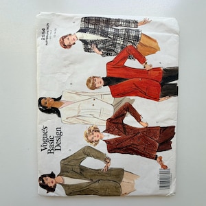 Op de afbeelding: Een vintage Vogue's Basic Design naaipatroon, met illustraties van damesblazers in verschillende stijlen. Het patroon bevat een reeks maten, aangegeven op de omslag. Het kleurenpalet omvat witte, rode, bruine en groene blazers.