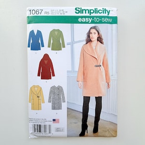 May include: Simplicity sewing pattern 1067 for an easy-to-sew coat in sizes 14-22. The envelope features illustrations of five coat variations in blue, green, red, yellow, and grey, alongside a photograph of a peach-coloured coat with a toggle closure.