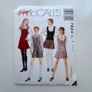Pode incluir: Um envelope de padrão de costura McCall's vintage com ilustrações de quatro designs de vestidos diferentes. O envelope é branco com o texto "Easy McCall's" em vermelho. O número do padrão é 7824, e o tamanho é B (8, 10, 12).
