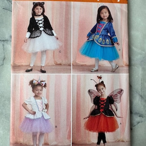 May include: Simplicity sewing pattern S8978 featuring four children's costume designs. The costumes include a cat, peacock, unicorn, and butterfly. The pattern includes sizes 1/2-2 and is marked "Since 1927".