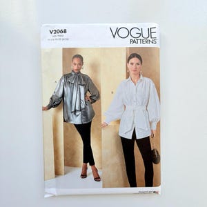 May include: A Vogue Patterns sewing pattern envelope labelled V2068, size Y5 (18-20-22-24-26). The front displays two blouse designs: a metallic silver long-sleeve shirt with a neck tie and a white button-down shirt with long sleeves and a waist tie.