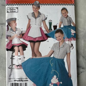Op de afbeelding: Simplicity patroon 3836 met een retro diner-thema kostuumontwerp. Het patroon toont meisjes in outfits met poedeljurken, schorten en geruite hoeden. De maten zijn K5 7,8,10,12,14.