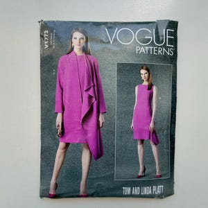 Op de afbeelding: Vogue Patterns naaipatroon met een vrouw in een magenta jas en jurk. Het patroon bevat een jas met een gedrapeerde voorkant en een mouwloze jurk. Het patroon is gelabeld V1773.