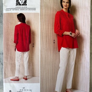 May include: A sewing pattern by Anne Klein for Vogue Patterns. The pattern features a red tunic top and white trousers. The image shows the front and back views of the outfit. The pattern number is V1509.