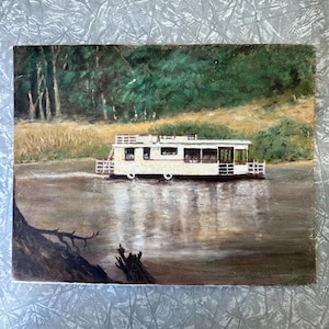 May include: Oil painting of a white houseboat floating on a brown river. The boat has windows and a railing. Green trees and a grassy bank are in the background. The water reflects the boat and the sky.