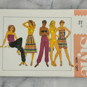 May include: Vintage sewing pattern featuring illustrations of women in various summer outfits. The pattern includes a strapless top, skirt, pants, bikini, and a strapless dress. The pattern is labeled "Style" and includes the size 10.