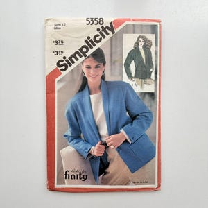 Könnte beinhalten: Eine Simplicity 5358 Schnittmusterhülle für einen Blazer in Größe 12 Miss. Das Cover zeigt einen blauen Blazer mit Schalkragen, langen Ärmeln und aufgesetzten Taschen. Der Text umfasst Simplicity, 5358, Size 12 Miss und Ricki for Finity.