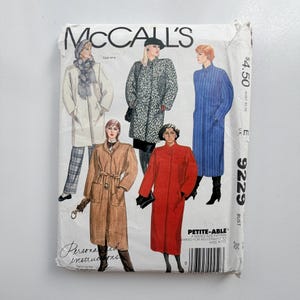 Può includere: Una busta per cartamodello McCall's per un cappotto, numerata 9229, con illustrazioni di cinque diversi stili di cappotto in vari colori e fantasie, tra cui un cappotto beige con cintura, uno rosso, uno blu a righe e uno leopardato.