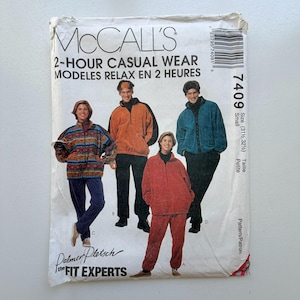 Op de afbeelding: McCall's naaipatroon voor 2-uurs vrijetijdskleding. Het patroon toont afbeeldingen van fleece jacks en broeken in verschillende kleuren, waaronder oranje, blauwgroen en rood. De patroongrootte is klein, met afmetingen van 80 en 82,5 cm.